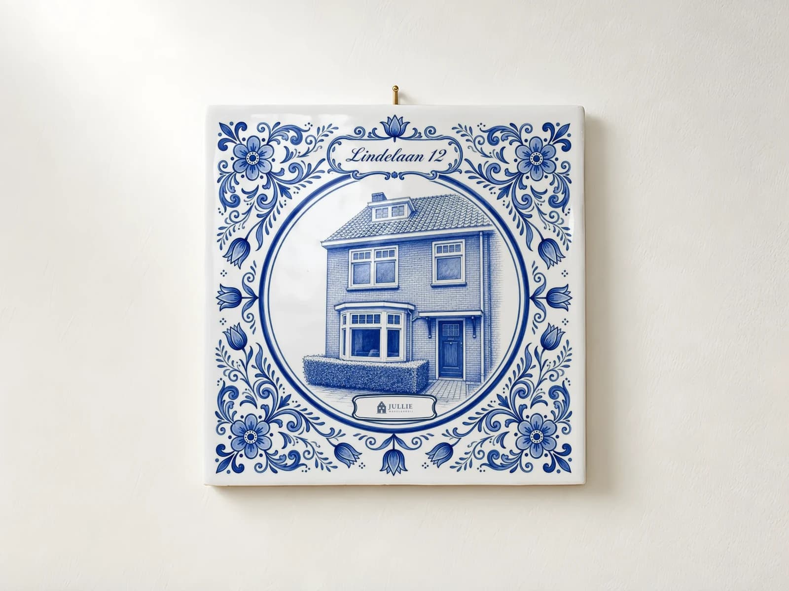 Delfts blauw tegeltje van een woning aan de muur