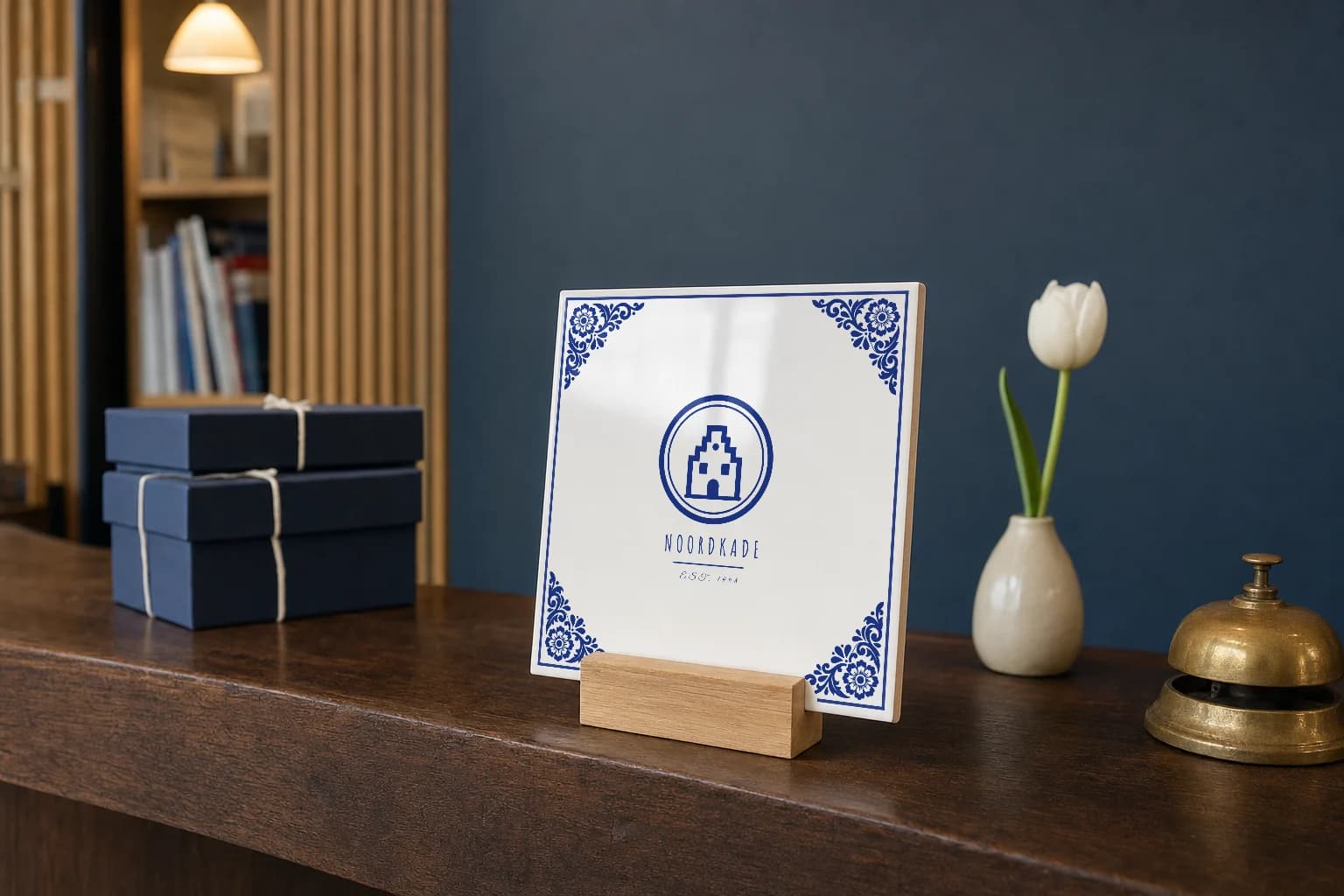 Carreau logo bleu de Delft sur un support en chêne, posé sur le comptoir d’accueil d’un bureau